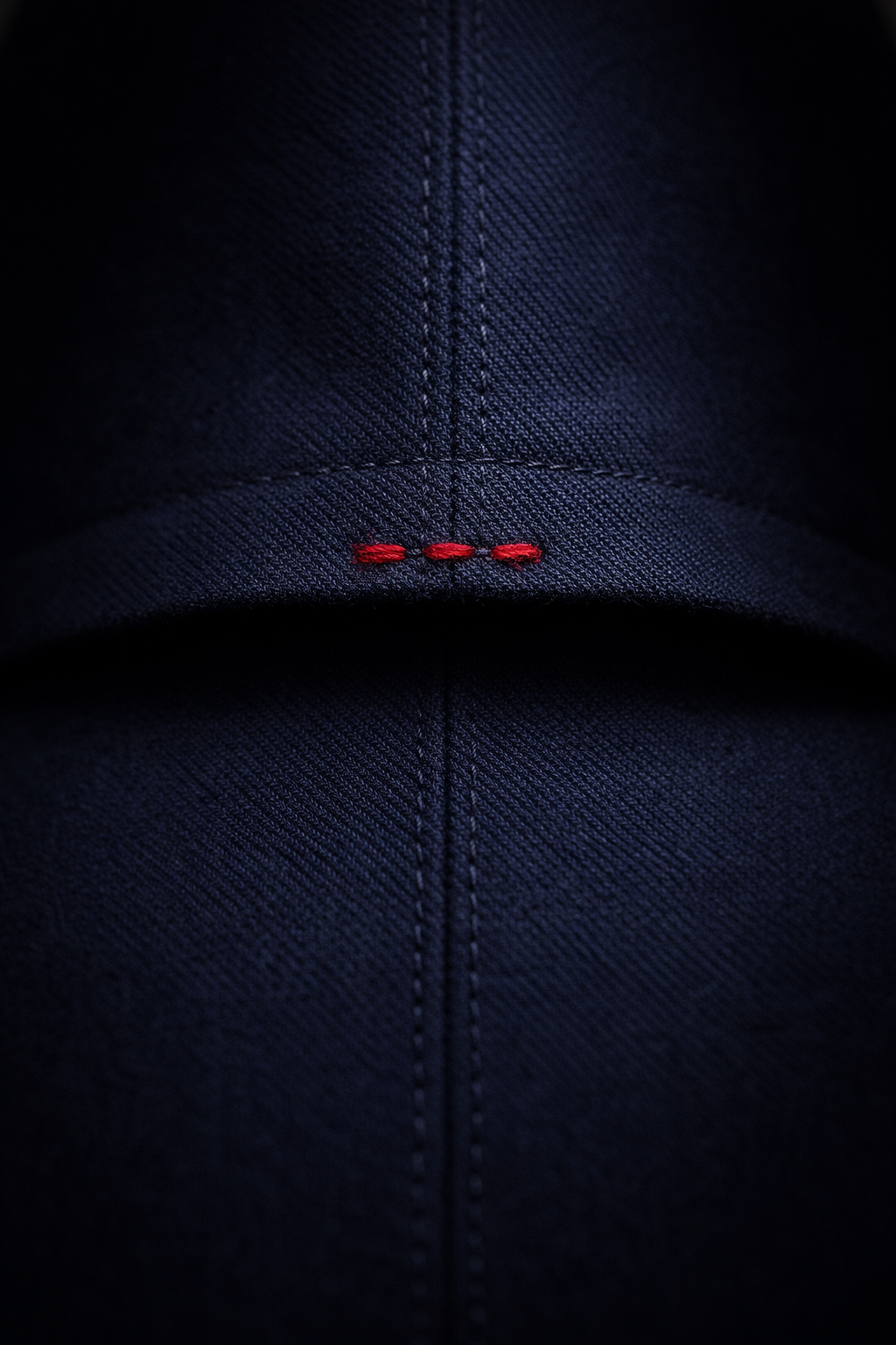 Imbastitura rossa a vista sul denim.